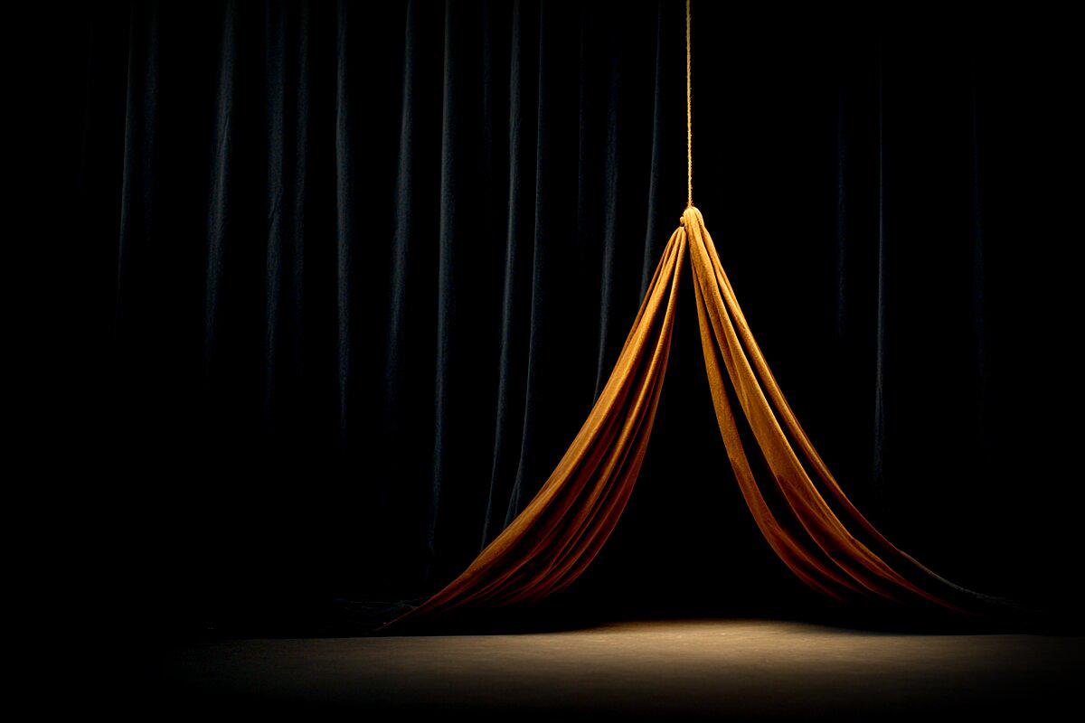 An amber dress pulled by a string on an empty stage - the costume that dances with no one inside